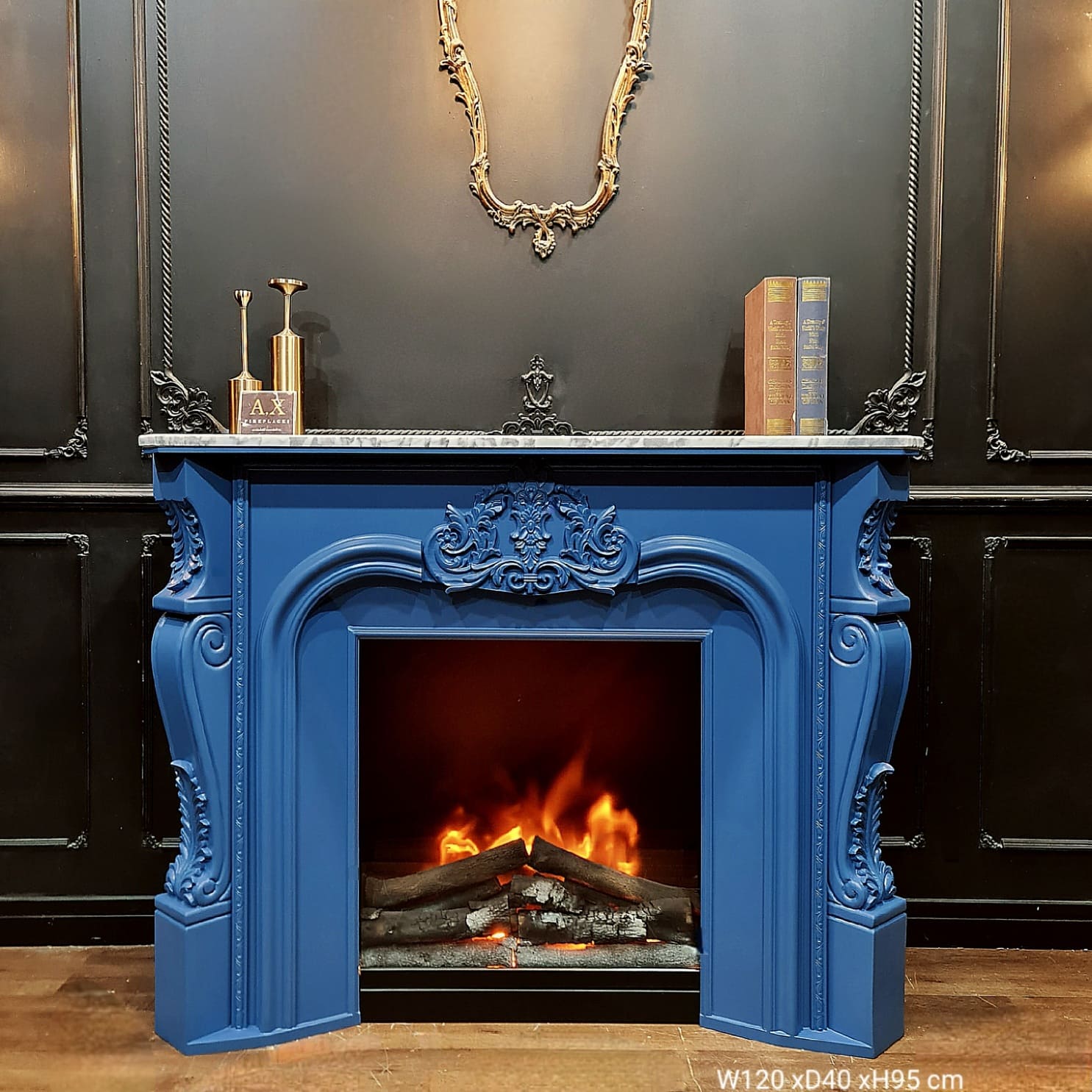 เตาผิงตกแต่งบ้าน รุ่น AX88 โดดเด่นด้วยตู้สีน้ำเงิน (Navy Blue) และท็อปด้านบนลายหินอ่อนสีดำ จัดวางคู่กับของตกแต่งสไตล์วินเทจ สร้างจุดเด่น (Focal Point) ให้ผนังห้อง